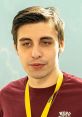 Young man with dark hair and a maroon shirt wearing a yellow lanyard, representing gaming culture and Shroud's influence.