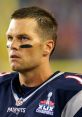 Tom Brady focused during a game, wearing a Patriots jersey with the Super Bowl champions logo prominently displayed.