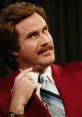 Ron Burgundy in a red suit gives a knowing look, showcasing his iconic style from "Anchorman." Classic 70s news vibe.