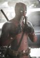 Deadpool holding two guns poses dramatically in a gritty urban setting, showcasing his iconic red and black costume.