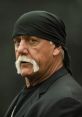 Hulk Hogan in a black bandana, showcasing his signature mustache and intense gaze, embodying wrestling charisma.