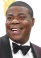 Tracy Morgan shares a joyful moment at an awards ceremony, showcasing his signature smile in a classic tuxedo.