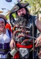 Colorful pirate duo at a festival, featuring a bearded pirate with guns, and a woman in a historical costume.