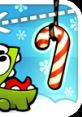 Cute green creature from Cut the Rope reaching for a striped candy cane in a festive, snowy background.