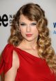 Taylor Swift with glamorous makeup and a red dress, showcasing her elegant style at a prominent event.