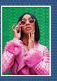 Cardi B poses confidently in a pink fur coat and stylish sunglasses against a vibrant green background, showcasing her fashion sense.