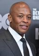 Dr. Dre, renowned music producer and rapper, smiling in formal attire at a red carpet event.