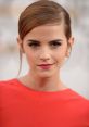 Emma Watson showcasing a chic look with elegant makeup and a statement red dress, exuding confidence at an event.