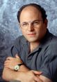 Jason Alexander posing for a portrait, wearing glasses and a casual shirt, showcasing his signature style and personality.