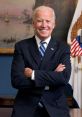 Joe Biden smiling confidently in formal attire, standing with arms crossed in an official setting.