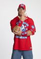 John Cena posing in a red "Never Give Up" shirt and matching accessories, showcasing his iconic wrestling persona.