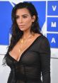 Kim Kardashian showcases a glamorous look with wet hair and layered gold jewelry at the VMAs, exuding confidence and style.