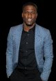 Kevin Hart smiling confidently, wearing a stylish patterned blazer over a black shirt, showcasing a vibrant personality.