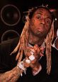 Lil Wayne showcasing his signature style with elaborate jewelry and unique tattoos in a recording studio setting.