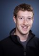 Mark Zuckerberg smiling, wearing a black jacket, with a plain blue background, representing innovation and leadership in tech.