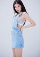 Jennie poses confidently in a stylish denim overall dress, showcasing her trendy fashion sense and iconic style.