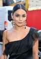 Vanessa Hudgens stunningly dressed in a black ruffled gown with statement earrings at a stylish event, showcasing her glam.