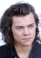 Close-up of Harry Styles with tousled hair and piercing blue eyes, showcasing his striking features and timeless style.