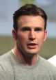 Chris Evans speaking at a panel, wearing a gray shirt, showcasing his thoughtful expression and distinctive style.