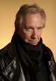 Alan Rickman in a stylish leather jacket and scarf, gazing thoughtfully with a warm yellow background.