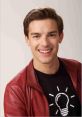 Cheerful young man in a red leather jacket and black t-shirt with lightbulb design, showcasing MatPat's creative persona.