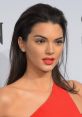 Kendall Jenner showcases a glamorous look with bold red lips and sleek hair, embodying high fashion elegance at an event.