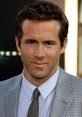 Ryan Reynolds smiles confidently in a stylish grey suit, showcasing his charismatic personality and charm.