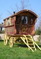 Colorful, intricately designed vintage wagon with ornate patterns, set against a vibrant green grass background.