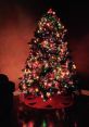 Colorful Christmas tree adorned with lights and ornaments, creating a festive holiday atmosphere in a cozy room.