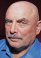 Don LaFontaine, legendary voiceover artist, known for iconic movie trailers, features intense expression and distinctive look.