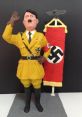 Plasticine figure of Adolf Hitler in uniform, saluting next to a Nazi flag, representing historical context and symbolism.