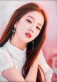 Jisoo from BLACKPINK poses elegantly, showcasing her signature style and beauty with long, flowing hair and statement earrings.