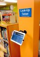 Look-Up Tablet at Gush Library, providing easy access to catalog and services for patrons. Press blue button to begin.