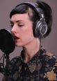 Australian female recording artist with headphones capturing voice for computer-generated audio production.