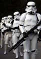 Stormtroopers in white armor marching in formation, holding rifles from the iconic Star Wars franchise.