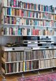 Cozy stereo library with shelves of books and vinyl records, featuring a turntable and audio equipment for music enjoyment.