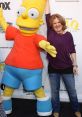 Nancy Cartwright poses with a Bart Simpson character, showcasing the iconic animated character from The Simpsons.