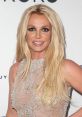 Britney Spears smiling proudly, wearing a sparkling outfit at an event, embodying her iconic pop star presence.