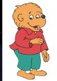 Cheerful cartoon bear from The Berenstain Bears, wearing a red shirt and green pants, embodying childhood innocence and fun.