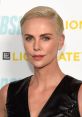 Charlize Theron showcasing a sleek short hairstyle and glamorous makeup at a red carpet event.