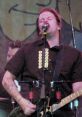 Jaret Reddick performing at Chuck E. Cheese, passionately singing into the microphone while playing guitar on stage.