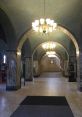 Grand empty entrance to a library featuring ornate chandeliers, archways, and marble columns, inviting tranquility and exploration.