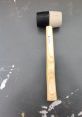 Rubber mallet with a black and gray head, featuring a wooden handle, ideal for library projects and non-damaging tasks.