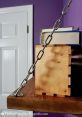 Metal chain strap securing books on a wooden shelf against a purple wall, adding a stylish touch to library decor.