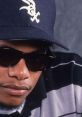 Eazy-E wearing sunglasses and a baseball cap, showcasing his iconic style in hip-hop culture during the '90s.