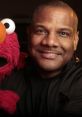 Kevin Clash smiles alongside Elmo, the beloved Sesame Street character, showcasing their iconic friendship and joy.