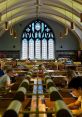 Interior of Coast Library featuring a vaulted ceiling, elegant stained glass, and students studying at wooden desks.