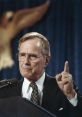 George H. W. Bush delivering a speech, emphasizing key points with a raised finger, set against a deep blue backdrop.