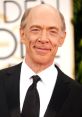 J.K. Simmons smiling at an awards event, showcasing his distinguished style and captivating personality.