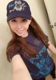 Jenny Nicholson smiles wearing a Star Wars graphic tee and matching cap, showcasing her passion for pop culture and fandoms.